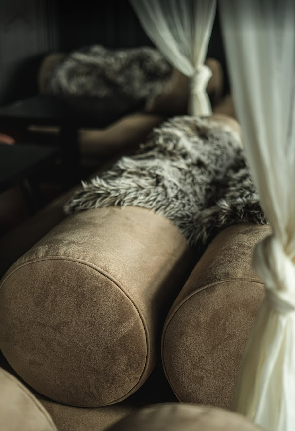 Velvet bolster cushions and faux fur throws in booth