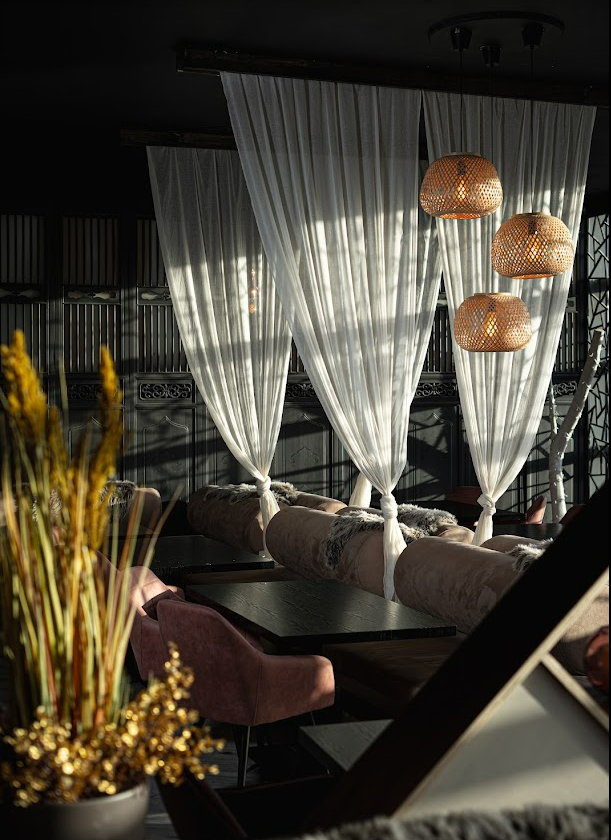 Sheer curtained booths with rattan pendants